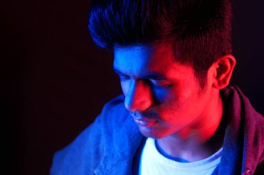 Üzgün ve bunalımlı bir adam Karanlıkta aşağıya bakıyor 