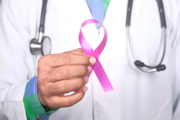 Hand holding pink color HIV ribbon close up — Stock Photo, Image