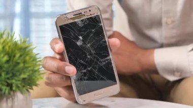 Kırık akıllı telefonu tutan adama yakın dur..