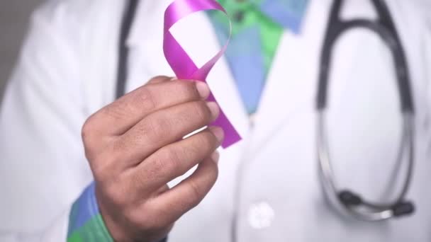 Ruka drží růžová barva HIV stuha zblízka — Stock video