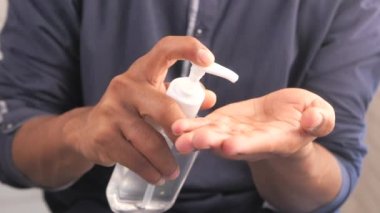 Virüsü önlemek için dezenfektan jel kullanarak genç adamın elini kapat. 