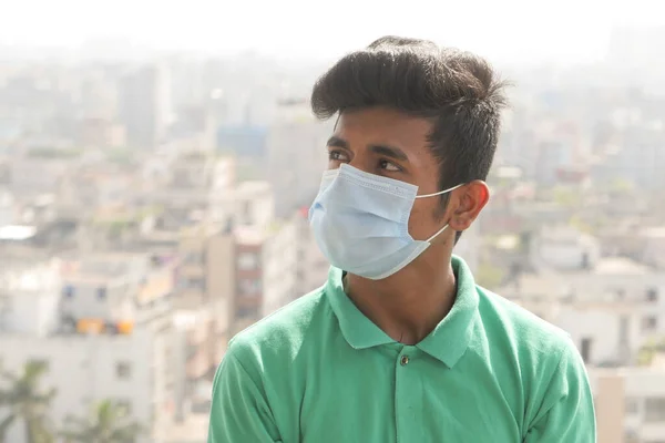 Jonge man met beschermend gezichtsmasker in de stad — Stockfoto