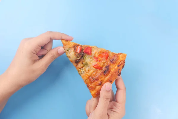 Mano che tiene una fetta di pizza al formaggio su sfondo a colori — Foto Stock