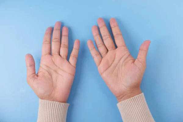 Frauenhand mit offenen Handflächen auf blauem Hintergrund — Stockfoto