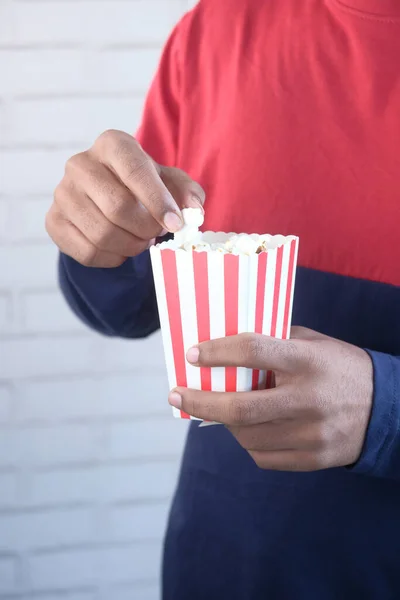 Junger Mann isst Popcorn aus nächster Nähe — Stockfoto