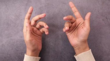 Kadın eli açık, avuç içi siyah arka planda. 