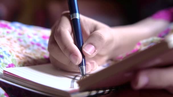 ปิดขึ้นของผู้หญิงมือเขียนบนแผ่นบันทึก . — วีดีโอสต็อก