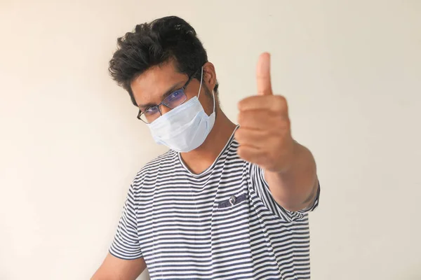 Een jonge man met een beschermend masker tegen een muur — Stockfoto