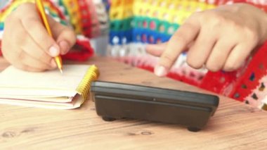 Kadınlar ofis masasında hesap makinesi kullanıyorlar. 