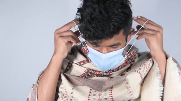 Junger asiatischer Mann setzt chirurgische Gesichtsmaske ins Haus — Stockvideo