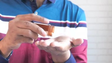 İlaç kutusundan dökülen ilaçlı adam eli. 