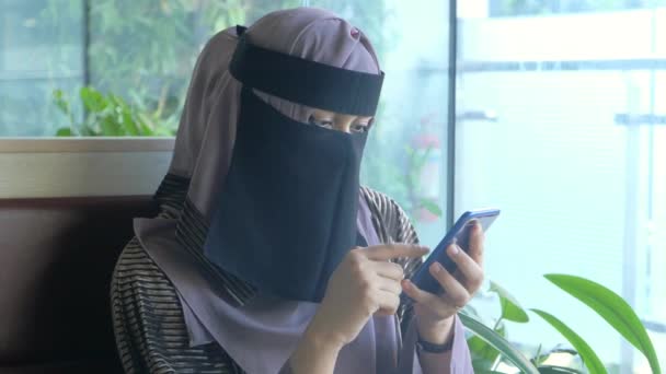 Mulheres muçulmanas com cachecol cabeça usando telefone inteligente interior — Vídeo de Stock
