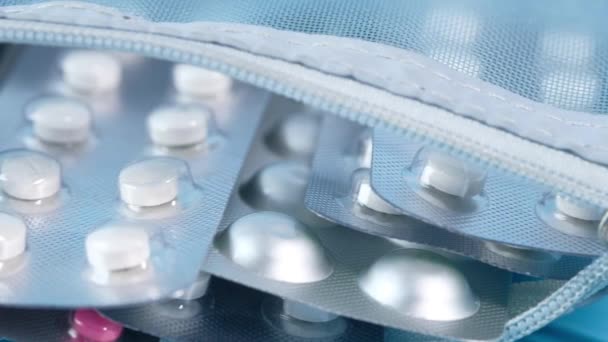 Close-up van pillen van blisterverpakking in een kleine zak op blauwe achtergrond — Stockvideo