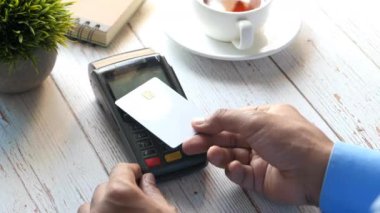 Kredi kartıyla ödeme yapan genç bir adamın arkadan görünüşü, temassız ödeme kavramı 