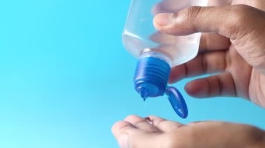 Mavi arkaplanda dezenfektan sıvısı kullanılıyor 