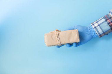 Mavi eldivenli erkek eli bir hediye veriyor..