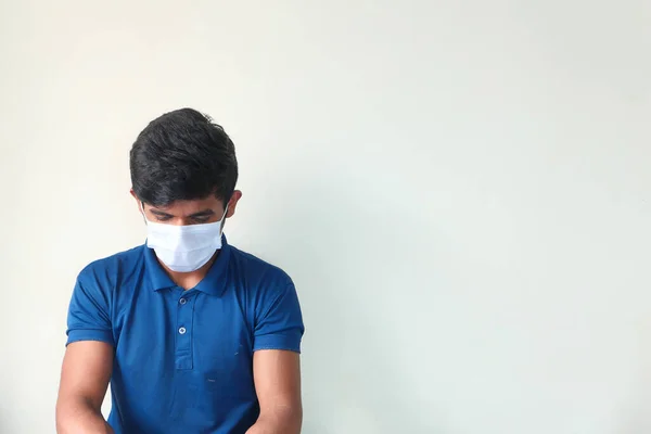 Een jonge man met een beschermend masker tegen een muur — Stockfoto