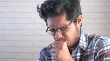  Genç Asyalı adam öksürüyor ve hapşırıyor. 