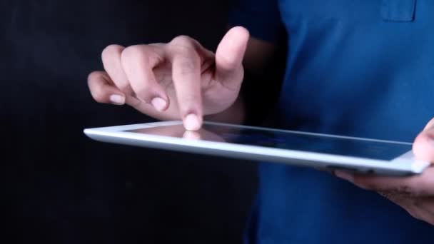 Рука человека с помощью цифровой таблички на чёрном фоне — стоковое видео