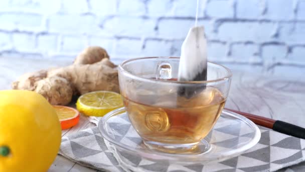 Cytryna i imbirowa herbata na drewnianym stole z bliska . — Wideo stockowe