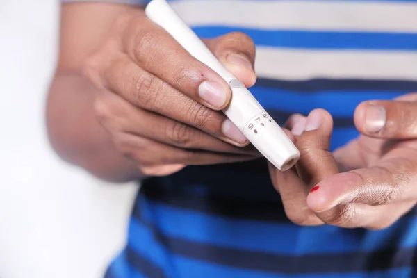 Giovani mans mano misurare il livello di glucosio isolato su bianco — Foto Stock