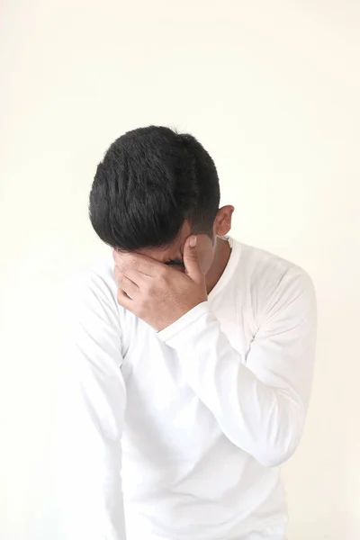 El joven se cubre la cara con dolor de cabeza en la mano, — Foto de Stock