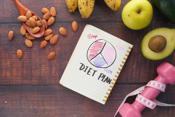 Dieta con mela, mandorla, avocado e manubri su fondo di legno — Foto Stock