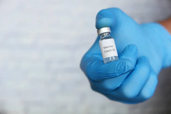 Mão em luvas segurando vacina coronavírus, com espaço de cópia — Fotografia de Stock