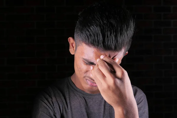 Jongeman lijdt aan hoofdpijn geïsoleerd op zwart — Stockfoto