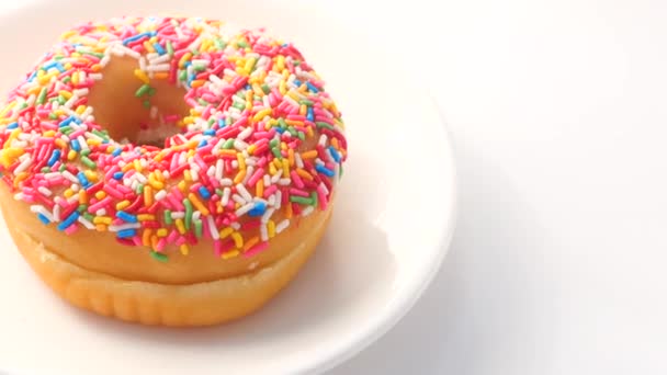 Donuts frescos coloridos na placa no fundo branco — Vídeo de Stock