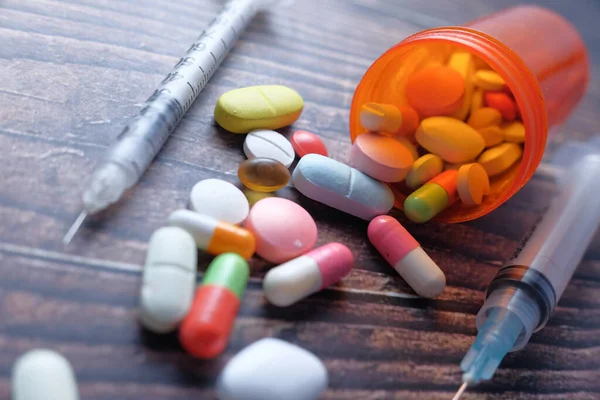 El concepto de sobredosis de drogas, jeringa y pastillas sobre fondo oscuro, de cerca — Foto de Stock
