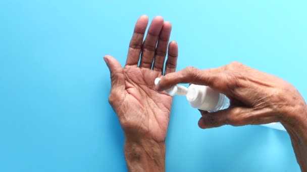 Пожилые женщины руки с помощью геля для дезинфекции для предотвращения вируса — стоковое видео