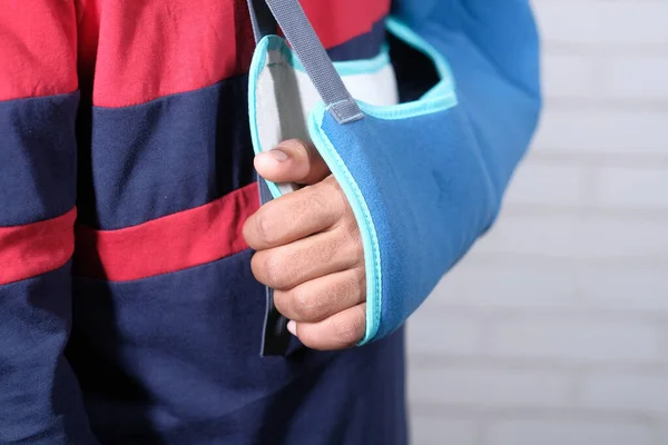 Young man wearing an arm brace for broken hand . — Stock Photo, Image