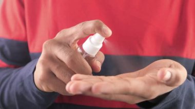 Delikanlının elini dezenfektan spreyiyle kapat..