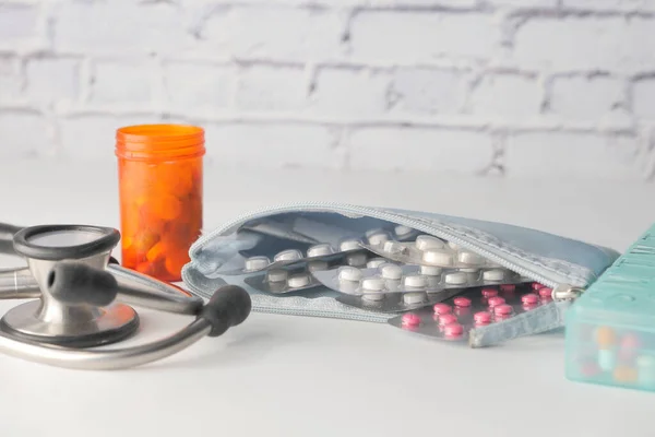 stethoscope and pills container on wooden background