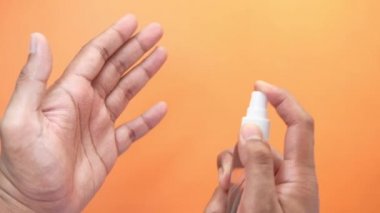 Delikanlının elini dezenfektan spreyiyle kapat..