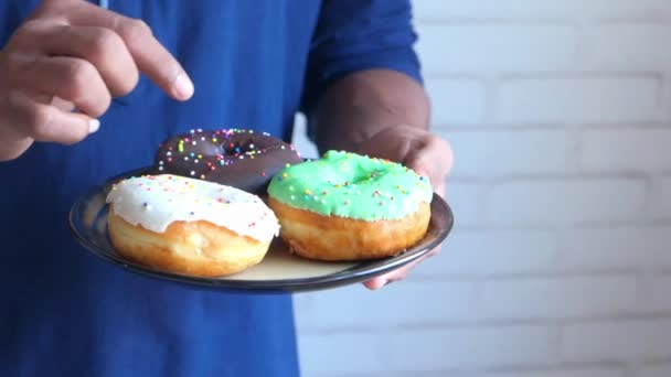 Mano recoger donuts frescos de cerca — Vídeo de stock