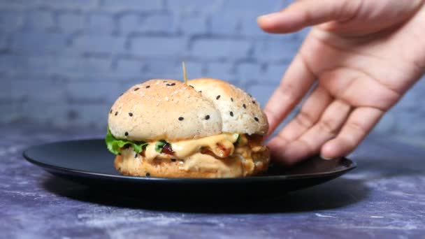 Mão segurando hambúrguer de carne na mesa de perto — Vídeo de Stock