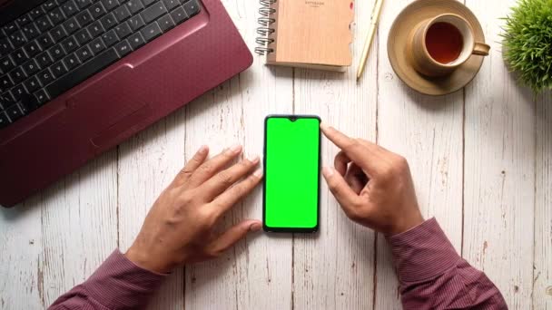 Бизнесмен с помощью смартфона с зеленым экраном на рабочем столе — стоковое видео