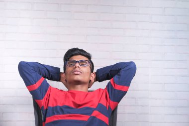  Üzgün genç adam bir sandalyede tek başına oturuyor. 