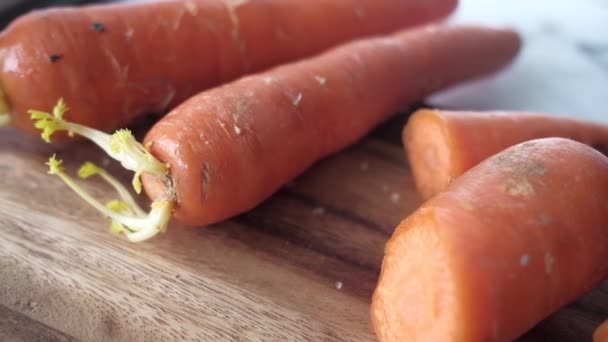 Zanahorias frescas en la tabla de cortar en la mesa — Vídeo de stock