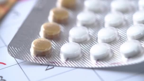 Birth control pills and calendar with red mark on table — Stock Video