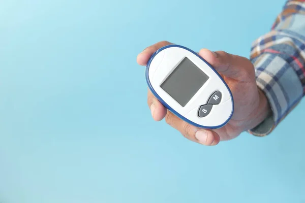 Sosteniendo herramientas de medición diabética sobre fondo azul —  Fotos de Stock