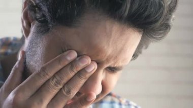 Güçlü göz ağrısından muzdarip üzgün adama yaklaş.