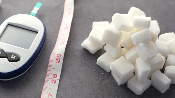 Alat ukur diabetes dan gula kubus ob latar belakang hitam — Stok Video