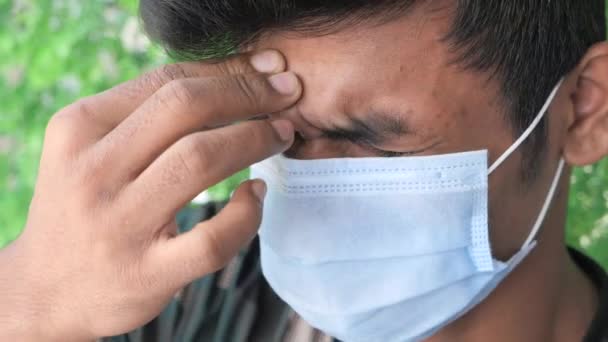 Primo piano dell'uomo con maschera protettiva che soffre di mal di testa — Video Stock