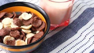  Çikolatalı mısır gevreğinin bir kâse içinde ve sütün üzerindeki bardağın en üst görüntüsü. 