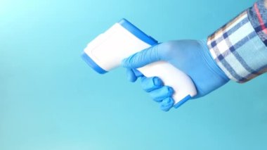 Sıcaklığı ölçmek için el ele tutuşan kızılötesi termometre.