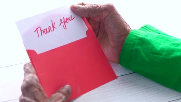 Mão de mulheres sênior segurando carta de agradecimento, visão traseira — Vídeo de Stock