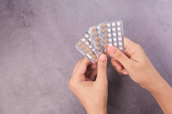 Vrouwen hand golding anticonceptiepillen op zwarte achtergrond — Stockfoto